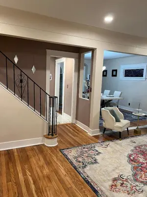 a living room with a staircase and a table at Elevated Entertainment Sleep Suite in Cleveland