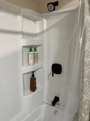 a bathroom with a bath tub with two bottles of soap at Elevated Entertainment Sleep Suite in Cleveland