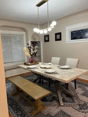 a dining room with a wooden table and chairs at Elevated Entertainment Sleep Suite in Cleveland