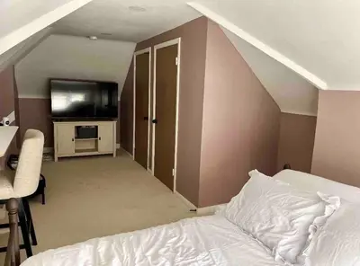 a bedroom with a bed and a tv and a desk at Elevated Entertainment Sleep Suite in Cleveland