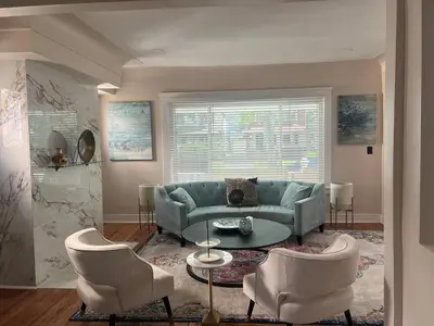 a living room with a blue couch and two chairs at Elevated Entertainment Sleep Suite in Cleveland