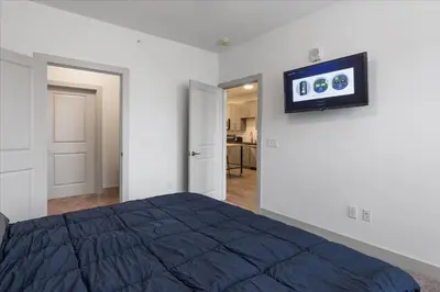 a bedroom with a bed and a tv on the wall at 3 Stylish apartments near shops and entertainment in Cincinnati