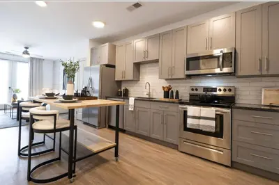 a kitchen with stainless steel appliances and a wooden table at 3 Stylish apartments near shops and entertainment in Cincinnati
