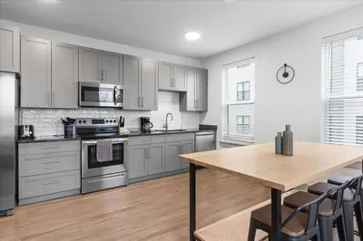 a kitchen with stainless steel appliances and a wooden table at 3 Stylish apartments near shops and entertainment in Cincinnati