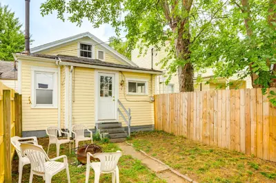a yellow house with chairs and a fence at Dog-Friendly Dayton Home 1 Mi to Downtown! in Dayton