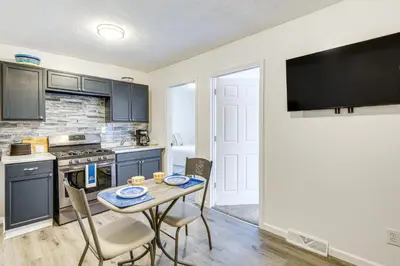a kitchen with a table and chairs and a kitchen with a tv at Walkable Barberton Apartment 9 Mi to Akron! in Barberton