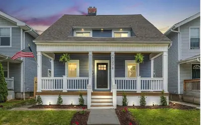 a house with a porch and an american flag at 5th Street Retreat Private Home OSU, Short North in Columbus