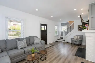 a living room with a gray couch and a fireplace at 5th Street Retreat Private Home OSU, Short North in Columbus