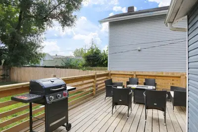 a patio with a grill and chairs on a deck at 5th Street Retreat Private Home OSU, Short North in Columbus