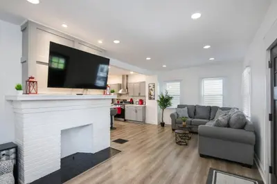 a living room with a fireplace with a tv above it at 5th Street Retreat Private Home OSU, Short North in Columbus