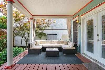 a screened porch with a couch and a table at Home with Garage, Hot Tub, near OSU & Short North in Columbus