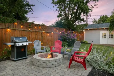 a backyard with chairs and a fire pit and a fence at Home with Garage, Hot Tub, near OSU & Short North in Columbus