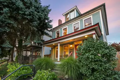 a house with a porch and a tree at Home with Garage, Hot Tub, near OSU & Short North in Columbus