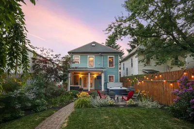 a blue house with a fence and a yard at Home with Garage, Hot Tub, near OSU & Short North in Columbus
