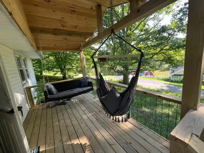 a hammock on a porch of a house at Hillside country cabin in Lancaster