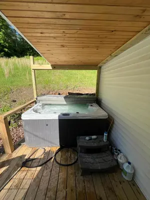a hot tub sitting on a wooden deck at Hillside country cabin in Lancaster
