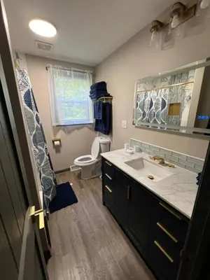 a bathroom with a sink and a toilet and a mirror at Hillside country cabin in Lancaster