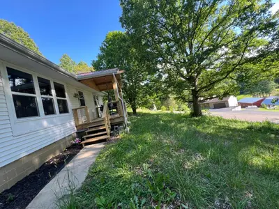 a house with a porch on the side of it at Hillside country cabin in Lancaster