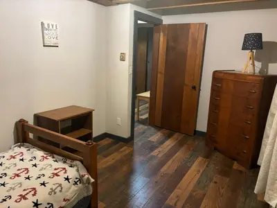 a bedroom with a bed and a dresser and a mirror at Farmhouse Cabin in Ashland