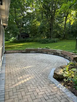 a brick driveway with a stone retaining wall at Farmhouse Cabin in Ashland