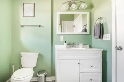 a bathroom with a toilet and a sink and a mirror at El Retro- Mid Century Ranch near Horse Park & Rupp in Lexington