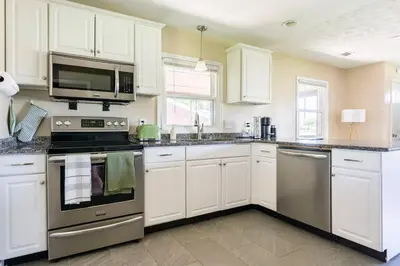 a kitchen with white cabinets and stainless steel appliances at El Retro- Mid Century Ranch near Horse Park & Rupp in Lexington