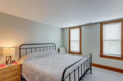 a bedroom with a bed and two windows at 3 Mi to Cedar Point Sunny Sandusky Home with Yard in Sandusky
