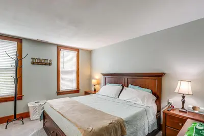 a bedroom with a large bed and two windows at 3 Mi to Cedar Point Sunny Sandusky Home with Yard in Sandusky