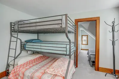 a bedroom with two bunk beds and a mirror at 3 Mi to Cedar Point Sunny Sandusky Home with Yard in Sandusky