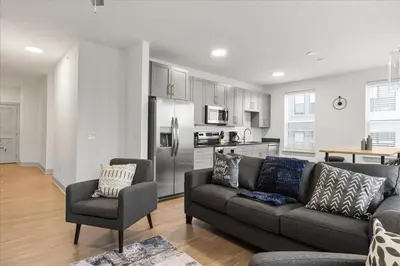 a living room with a couch and a kitchen at Stylish apartments near shops and entertainment in Cincinnati