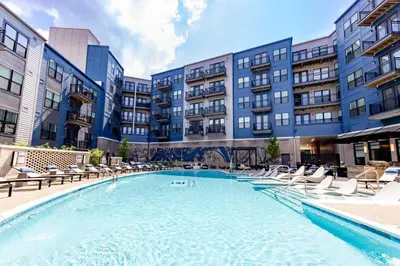 a large swimming pool with lounge chairs and buildings at Stylish apartments near shops and entertainment in Cincinnati