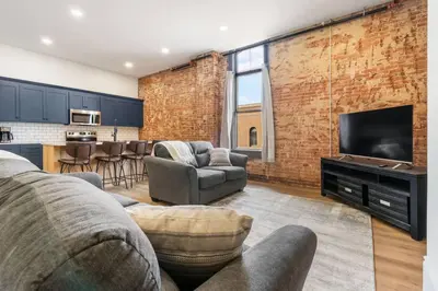 a living room with a couch and a television at Clay St Suite in Millersburg