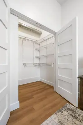 an empty closet with white doors and a wooden floor at Clay St Suite in Millersburg