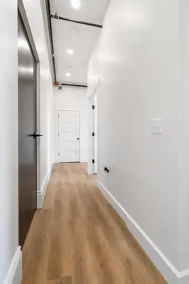 an empty hallway with white walls and wood floors at Clay St Suite in Millersburg