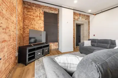 a living room with a couch and a flat screen tv at Clay St Suite in Millersburg