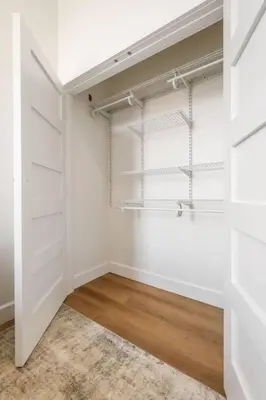 an empty closet with white walls and wooden floors at Clay St Suite in Millersburg