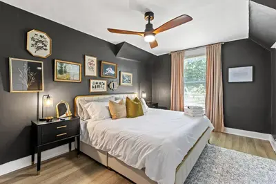 a bedroom with a large bed with a ceiling fan at The Luxe Hot Tub Private Bar 12 Min to Horse Park in Georgetown