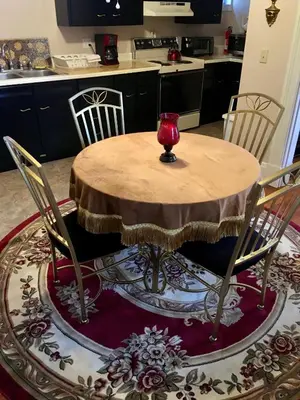 a wooden table with chairs and a red vase on it at Historic Upstairs Apartment in Bellevue