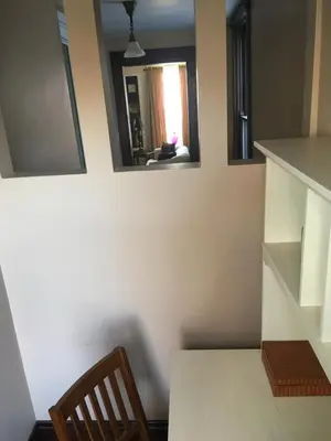 a table and a chair in a room with two mirrors at Historic Upstairs Apartment in Bellevue