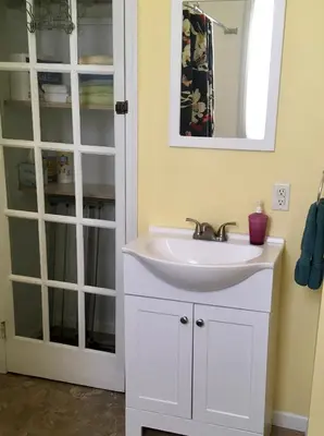 a bathroom with a white sink and a mirror at Historic Upstairs Apartment in Bellevue