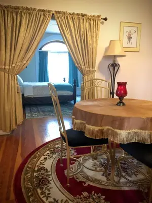 a dining room with a table and a bed at Historic Upstairs Apartment in Bellevue