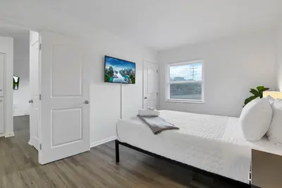 a white bedroom with a bed and a window at The Northtowne Getaway in Columbus