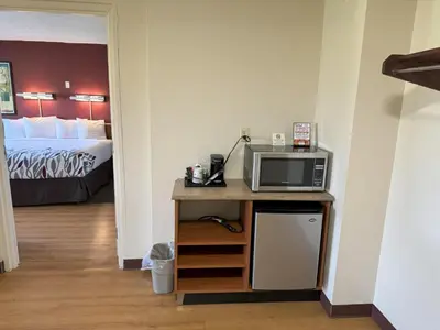 a room with a bed and a desk with a microwave at Sycamore Suites in Elyria