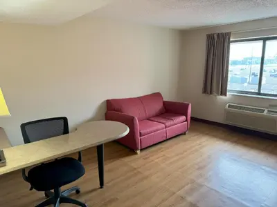 a living room with a pink couch and a table at Sycamore Suites in Elyria