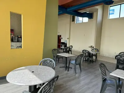 a dining room with tables and chairs and a yellow wall at Sycamore Suites in Elyria