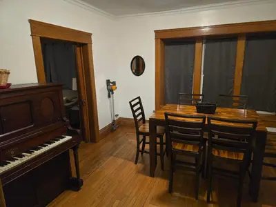 a dining room with a piano and a table and chairs at Unit 1 at Oilgate at Oakdale in Akron
