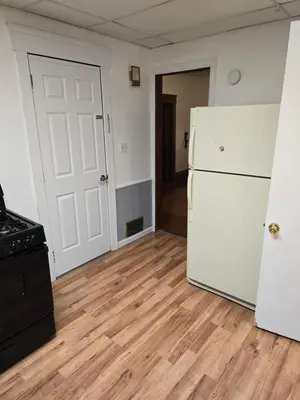 an empty kitchen with a refrigerator and a stove at Unit 1 at Oilgate at Oakdale in Akron