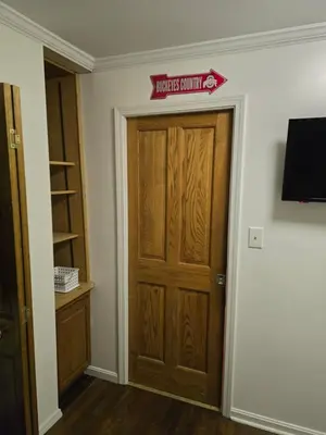 a room with a wooden door with a sign on it at Unit 1 at Oilgate at Oakdale in Akron