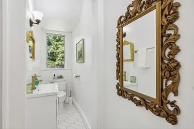a bathroom with a gold mirror on the wall at Enchanted Castle - Your Royal Getaway Awaits in Cleveland