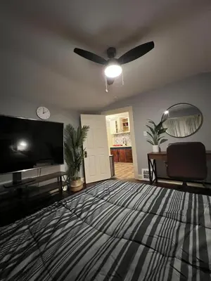 a living room with a ceiling fan and a flat screen tv at Parma duplex cozy retreat in Parma